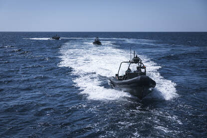 Links varen snelle FRISC-onderscheppingsboten over zee. Rechts klimmen Colombiaanse  mariniers via een ladder aan boord.