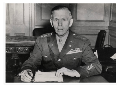Generaal George C. Marshall in uniform achter zijn bureau.