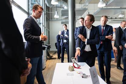 De staatssecretaris krijgt uitleg over een voorwerp.