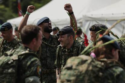 militairen vieren dat zij de finish van de Vierdaagse hebben bereikt