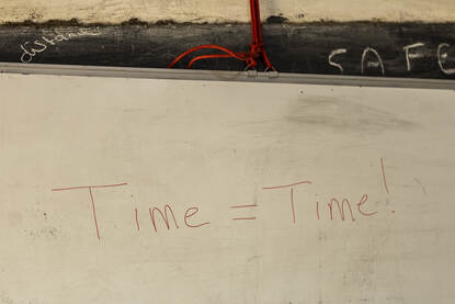 Time is time is met rode letters op het bord geschreven.