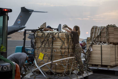 Links een foto waarop militairen een bundel inpakken. Rechts een militair die een pakket inspecteert voordat het aan boord gaat.