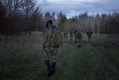 Mariniers op verkenning in een mistig bos en lopend door een weiland.