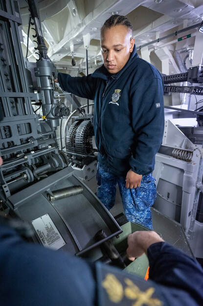 Een korporaal haalt lege hulzen uit de Goalkeeper.