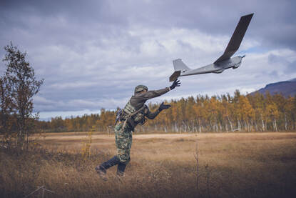 Links gooit een mariniers een drone de lucht in. Rechts rijdt een marinier op een quad met 6 wielen.