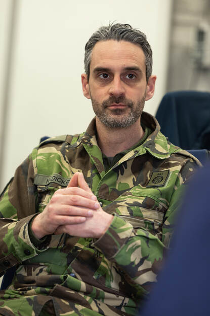 Luitenant-kolonel Martijn Hädicke luistert, zijn handen gevouwen.