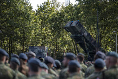 Militairen brengen de eregroet, staande voor een luchtverdedigingssysteem.