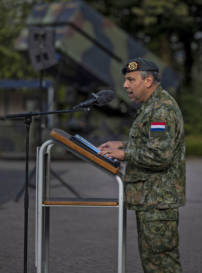 Kolonel Jos Kuijpers tijdens de oprichtingsceremonie, aan een spreekgestoelte.