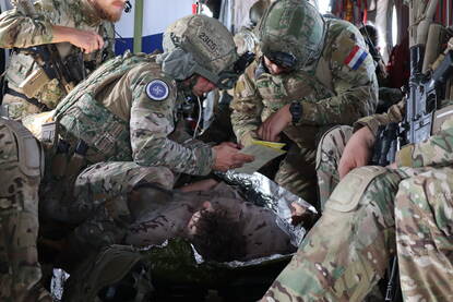 Militairen behandelen een oefengewonde.