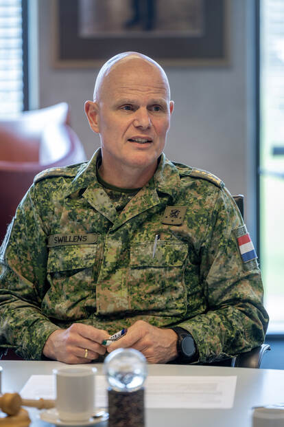 Militair op kantoor zit aan zijn bureau en is in gesprek.