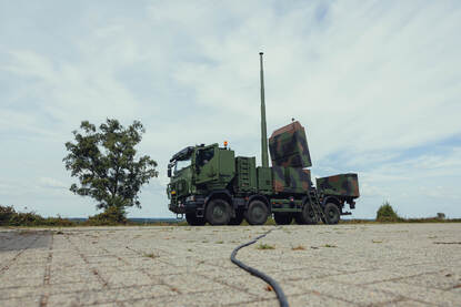 Links een foto van een raketlanceerinstallatie. Rechts de Multi Missie Radar gemonteerd op een Scania vrachtwagen.