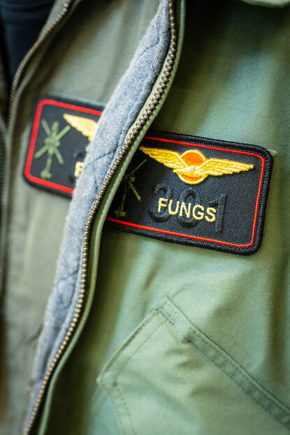 Een vliegerjasje met daarop het zwarte naamplaatje van TLT ‘Fungs’.