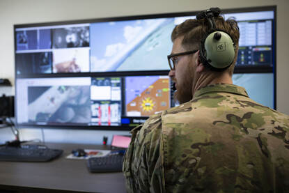 De instructeurs staat achter een groot scherm waarop alle omstandigheden in de simulator te volgen en aan te passen zijn.