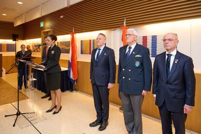 Rechts van spreker staat generaal-majoor b.d. Ton Tieland met naast hem nog twee gedecoreerden.