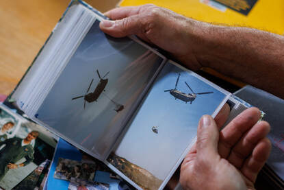 Een Chinook met als underslung een wrak van een helikopter.