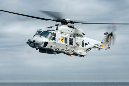 Helikopter vliegt boven zee.