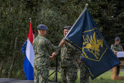 Commandant der Strijdkrachten generaal Onno Eichelsheim draagt de vlag van het NLD JFC over aan generaal-majoor Johan van Deventer. Daarnaast staan de twee naast elkaar in de houding.