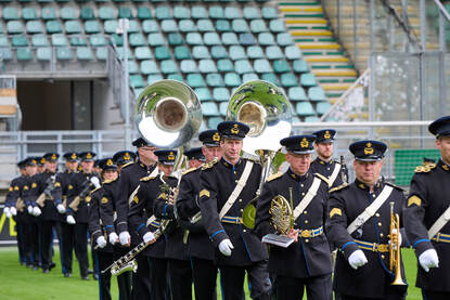 Verschillende afbeeldingen van de militairen in het stadion van ADO Den Haag op Prinsjesdag. Zichtbaar zijn het orkest, de gewapende troepen en de vaandelwacht.