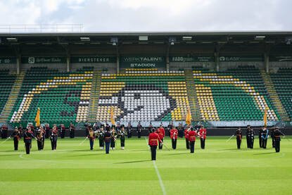 Verschillende afbeeldingen van de militairen in het stadion van ADO Den Haag op Prinsjesdag. Zichtbaar zijn het orkest, de gewapende troepen en de vaandelwacht.