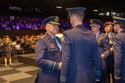 De CDS schudt een luchtmachter de hand tijdens de medaille-uitreiking.