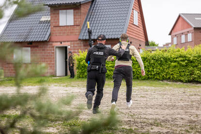 Een persoonsbeveiliger voert een iemand mee naar veiligheid.