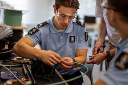 Leerlingen zittend voor een schakelbord in het practicumlokaal.