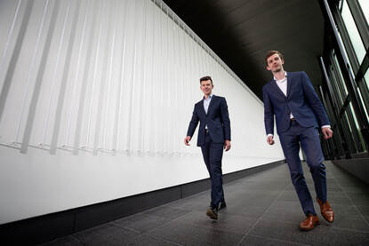 Dennis Neven en Michael Pieper lopen door een gang van het DMO-gebouw.