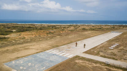 Luchtfoto van landingsbaan met drones en twee operators.