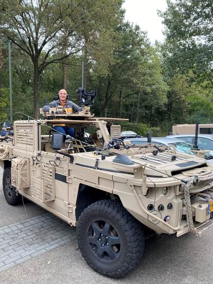 Chris Christodoulatos met koptelefoon in voertuig.