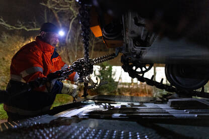 Medewerkers zekert met kettingen een rupsvoertuig.
