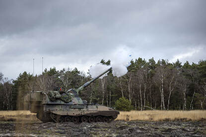 Een Pantserhouwitser vuurt, de granaat verlaat net de schietbuis.