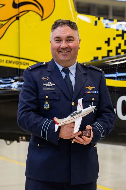 Portretfoto van majoor Casper. In zijn handen een modelvliegtuigje.