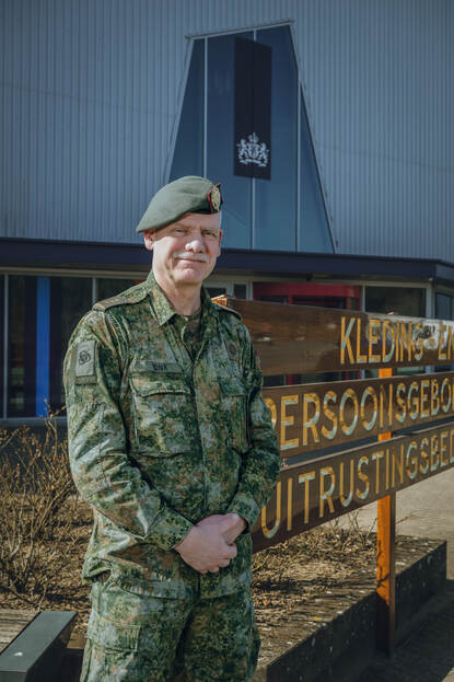 Commandant KPU-bedrijf kolonel Jan Vonk voor het gebouw van de Centrale Kleding.