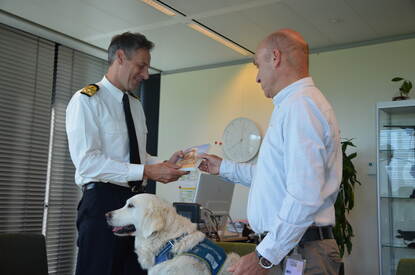 Auteur Royan van Velse overhandigt zijn boek aan de commandant van COMMIT