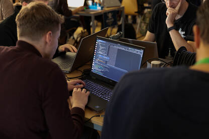 Een aantal personen achter hun laptop.